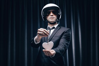 Portrait of a man in a helmet. He stands behind a curtain in the cabin and shows passengers a heart shape. The concept of travel