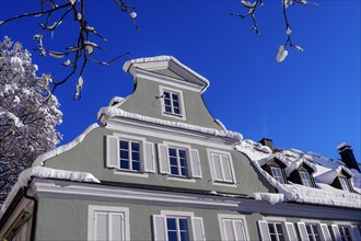 Classicist gable and gabled dormer with fresh snow