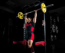 The weightlifter raises the barbell above his head and fixes the weight