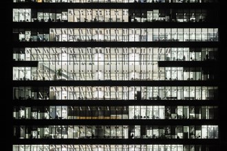 Series of offices at night in a modern building seen from the outside