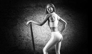 Charming girl posing with a bodybar. The concept of fitness