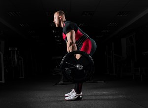 The weightlifter performs an exercise called deadlift. He fixed the weight