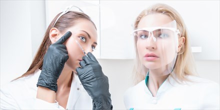 Portrait of two girls in white coats. The concept of cosmetology