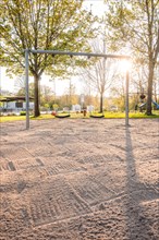 Sunny playground with swings and sandy area