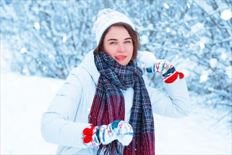 Portrait of a beautiful girl throwing a snowball. Concept for Christmas holidays