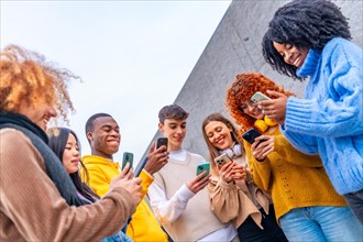 Low angle view of a group of friends using phone in the city