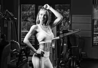 Charming young sportswoman posing in the gym. Bodybuilding concept. Sport. Weightlifting.