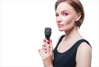 Portrait of an elegant stylish woman with a microphone. White background. Karaoke concept.