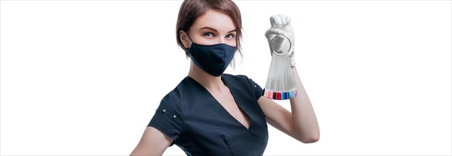Portrait of an elegant beautiful girl wearing a protective mask with a set of nail palette in hand. White background. Advertising banner for beauty salons during Covid-19. Pandemic. Modern trends.