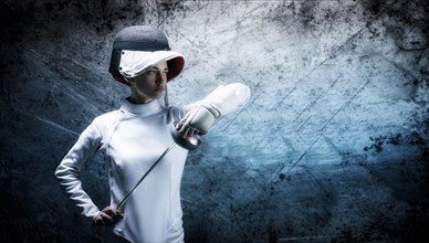 Charming girl dressed as a fencer posing with a mask and a sword. The concept of fencing.