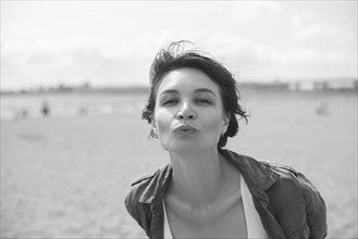 Portrait of a woman sending a kiss to the camera. Windy weather. Happiness