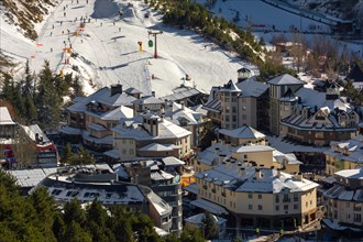 A mountain village nestled among snow-covered slopes with ski runs and alpine buildings
