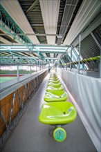 Empty green rows of seats in an interior corridor of a covered stadium