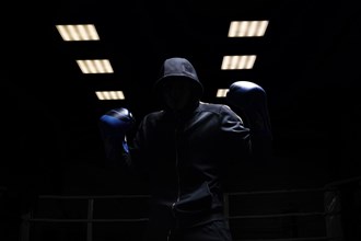 Fighter without a face is standing with his hands up. The concept of boxing
