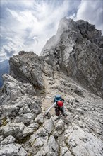Mountaineer climbing on a narrow rocky ridge