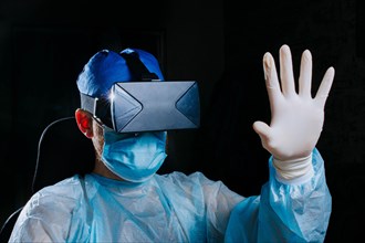 Male doctor surgeon in uniform and VR glasses helmet