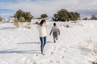 Child and mother having fun in snowy landscape