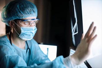 Surgeon examines fluorography images on a monitor in an operating room of a medical office