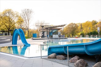 Empty outdoor pool with large water slides and clear blue sky