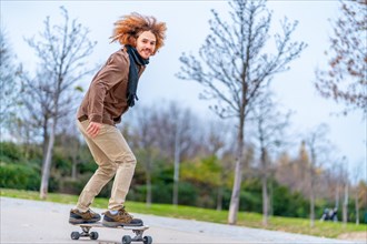 Skater with curly redhead hair on a board in an urban park