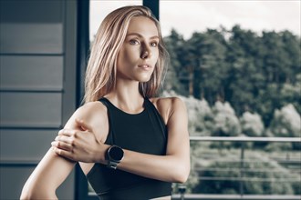 Charming girl posing with a smart watch. The concept of bodybuilding