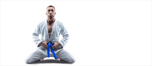 Athlete in a kimono with a blue belt sits and waits for the opponent. Concept of karate