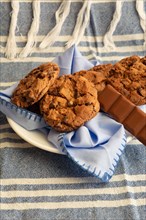 Homemade chocolate cookies and a chocolate bar on a striped cloth