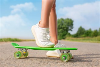 Image of female legs with a skateboard. Recreation and entertainment concept. Sport.
