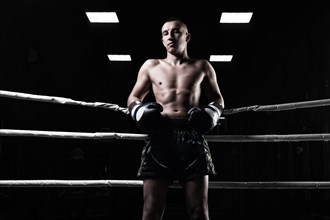 Portrait of a kickboxer who is standing in the ring. Sports concept