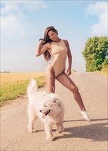Portrait of a beautiful sexy woman in a bodysuit walking a dog. Love