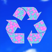 The universal recycling symbol. It is an internationally recognized symbol for recycling. Against blue sky