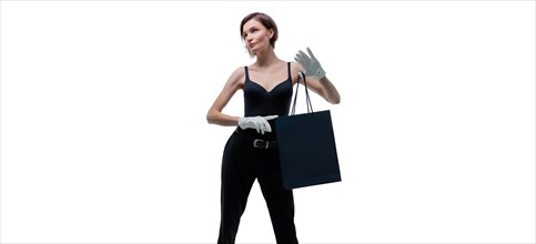 Stylish tall girl in white gloves demonstrates a black luxury package. The concept of safe shopping during a pandemic.