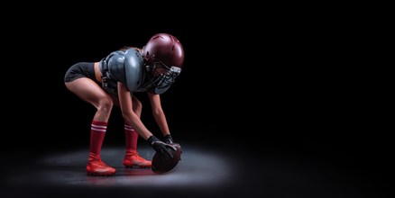 Image of a girl in the uniform of an American football team player. Beginning of the game. Sports concept. Shoulders pads.