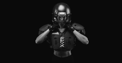 Portrait of a girl in the uniform of an American football team player. Black background. Sports concept.