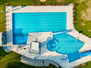Aerial view of a spacious swimming pool with a variety of pools and slides