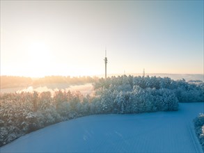 Sunrise over a snow-covered landscape with antennas in the background