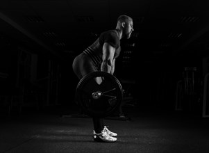 The weightlifter performs an exercise called deadlift. He fixed the weight