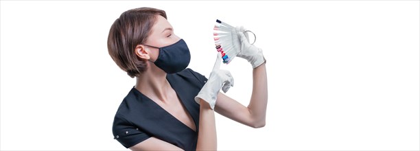 Portrait of an elegant beautiful girl wearing a protective mask with a set of nail palette in hand. White background. Advertising banner for beauty salons during Covid-19. Pandemic. Modern trends
