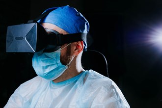 Male doctor surgeon in uniform and VR glasses helmet