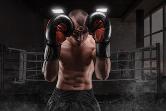 Image of a boxer in the gym. He covers his head with gloves. Protective rack. Mixed martial arts. Sports concept