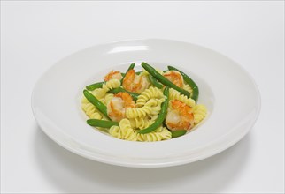 Gourmet pasta with tiger prawns and green beans. Top view. White background. Healthy eating concept.