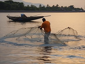 Fisherman on a river casting a net from his boat at dusk