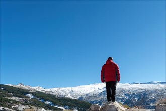 Man standing on the edge of a cliff and contemplating nature's creation in sierra nevada