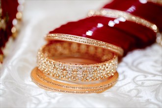 Close-up of traditional golden bangles on a red velvet background exuding luxury and elegance