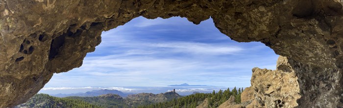 View through a rock arch to Roque Nublo and the Teide mountain peak on the neighbouring island of Tenerife