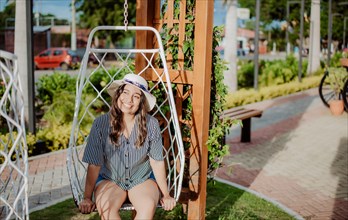 A smiling girl sitting on a swing in La Calzada
