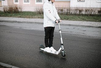 Young stylish guy rides an electric scooter around the city