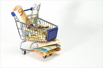 Shopping cart full of euro coins and banknotes