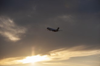 Passenger plane taking off in front of evening sky