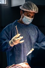 Latin surgeon performing a surgical procedure in an operating room